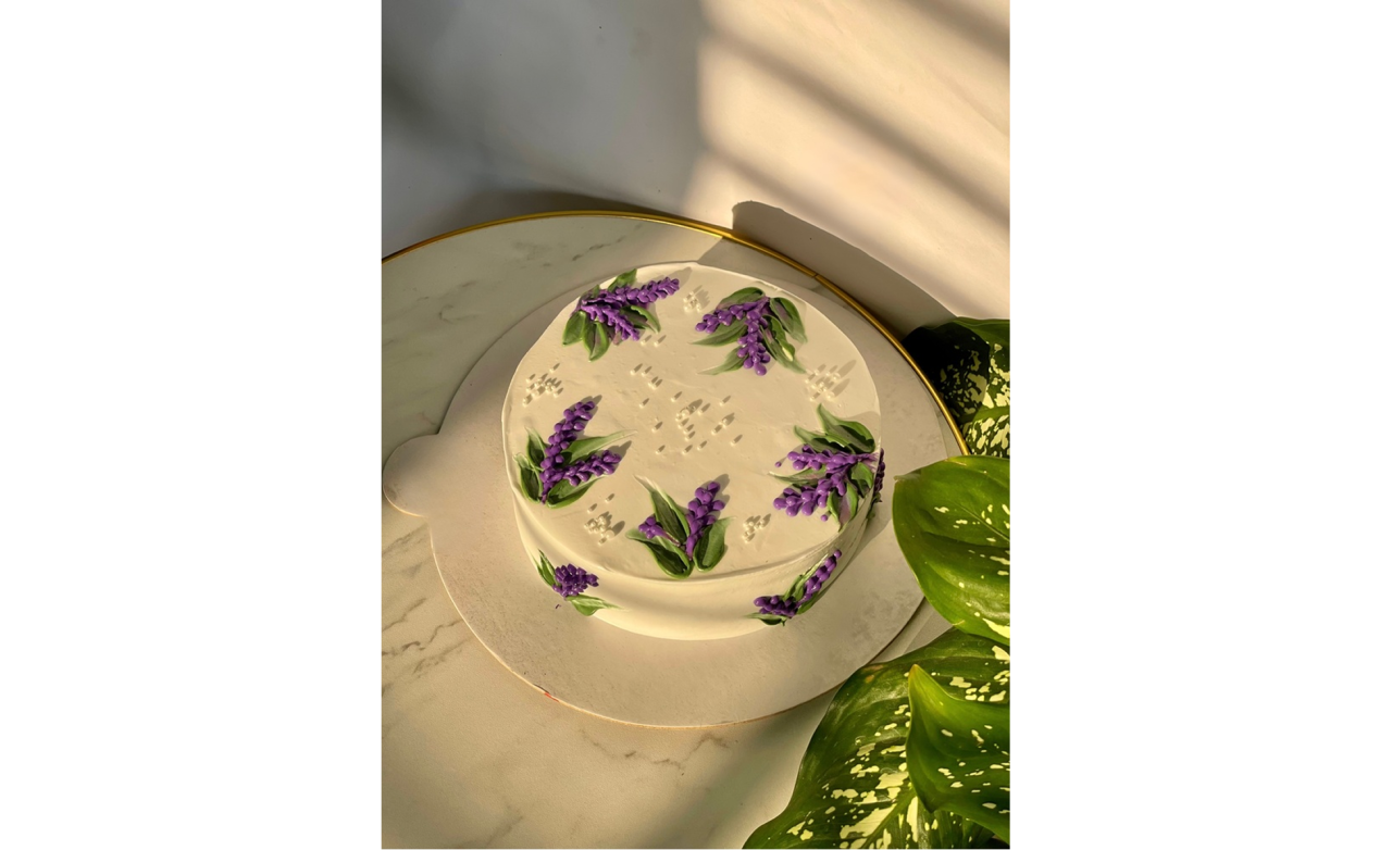 White cake with purple flowers in soft sunlight | Skylum Blog

