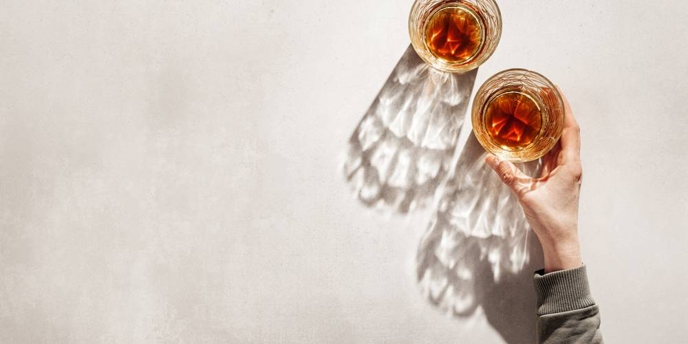 Top view of hands holding drink glasses in sunlight | Skylum Blog


