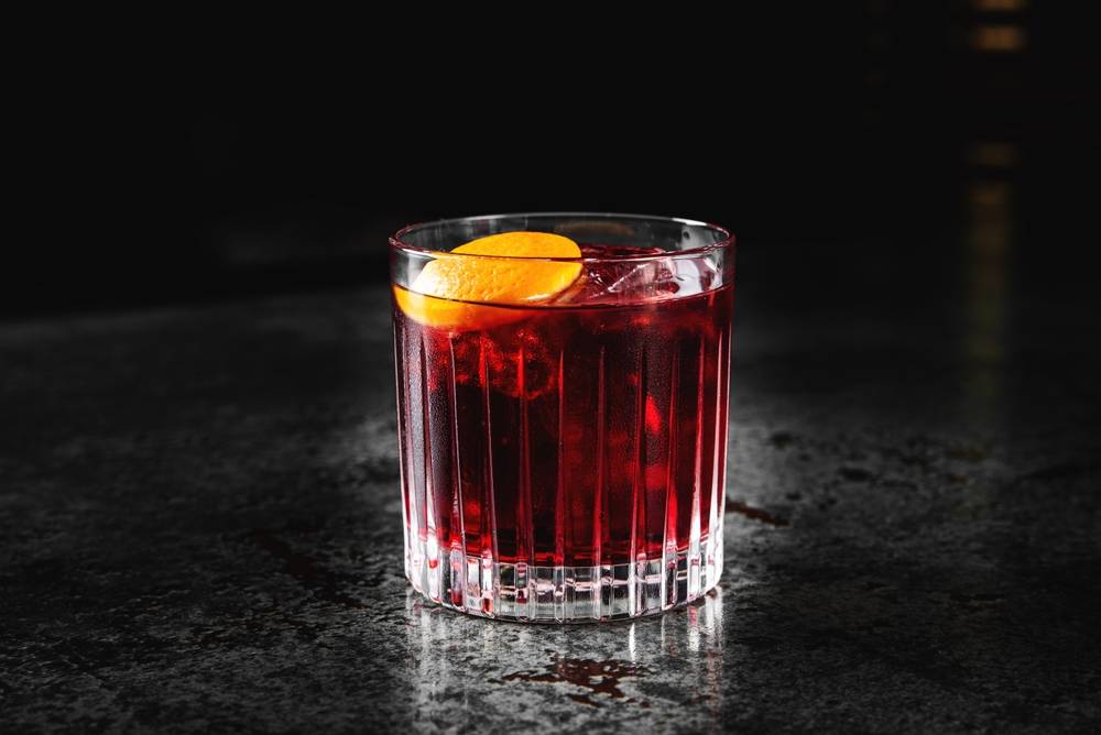 Red cocktail in a glass on a dark moody background | Skylum Blog

