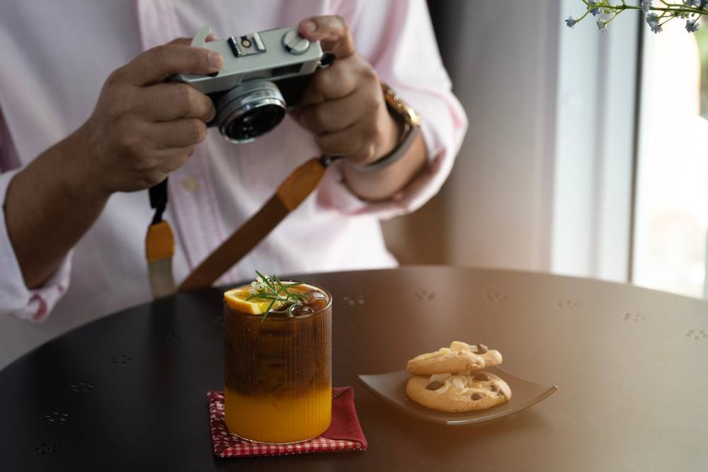 Person taking photo of a coffee drink with camera | Skylum Blog

