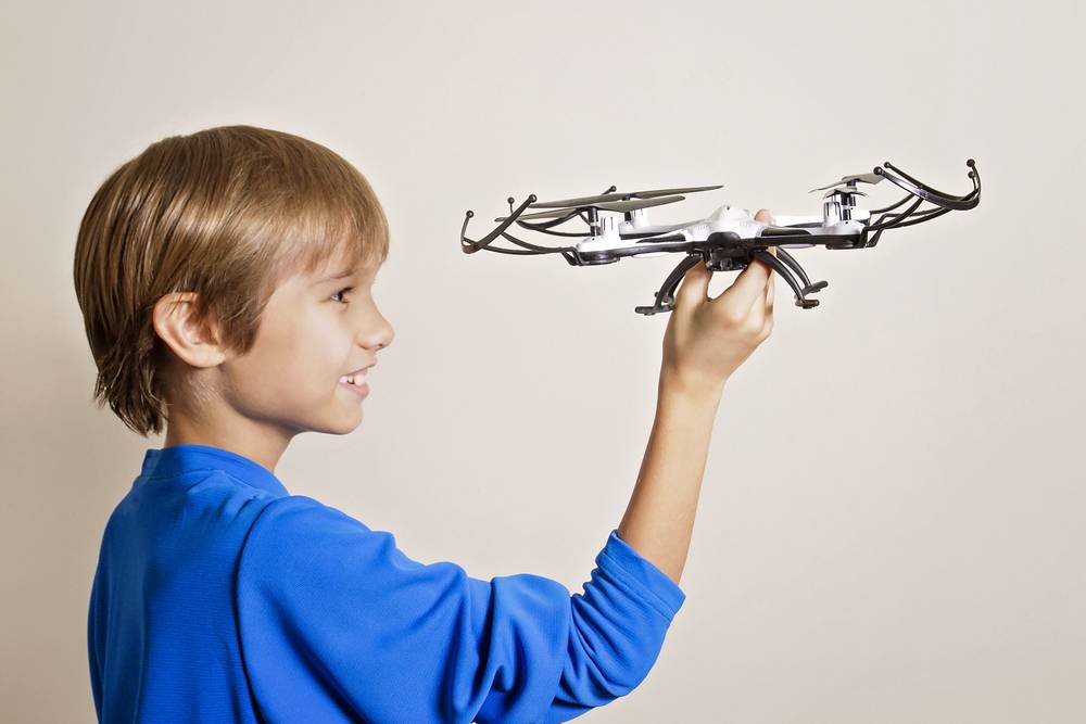 Boy holding a small toy drone