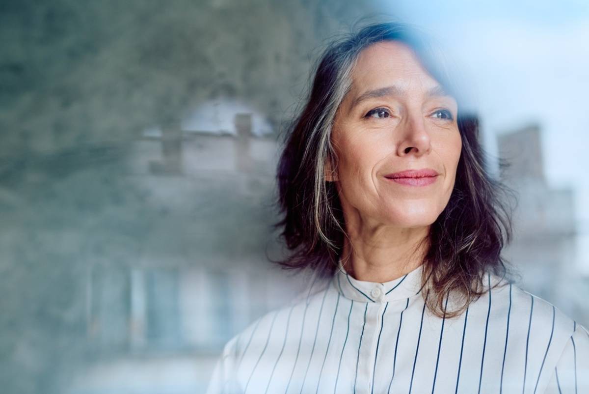 Woman looking at the camera through glass | Skylum Blog

