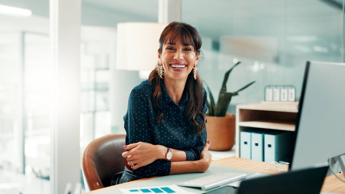 Woman sitting at a desk in a bright office | Skylum Blog

