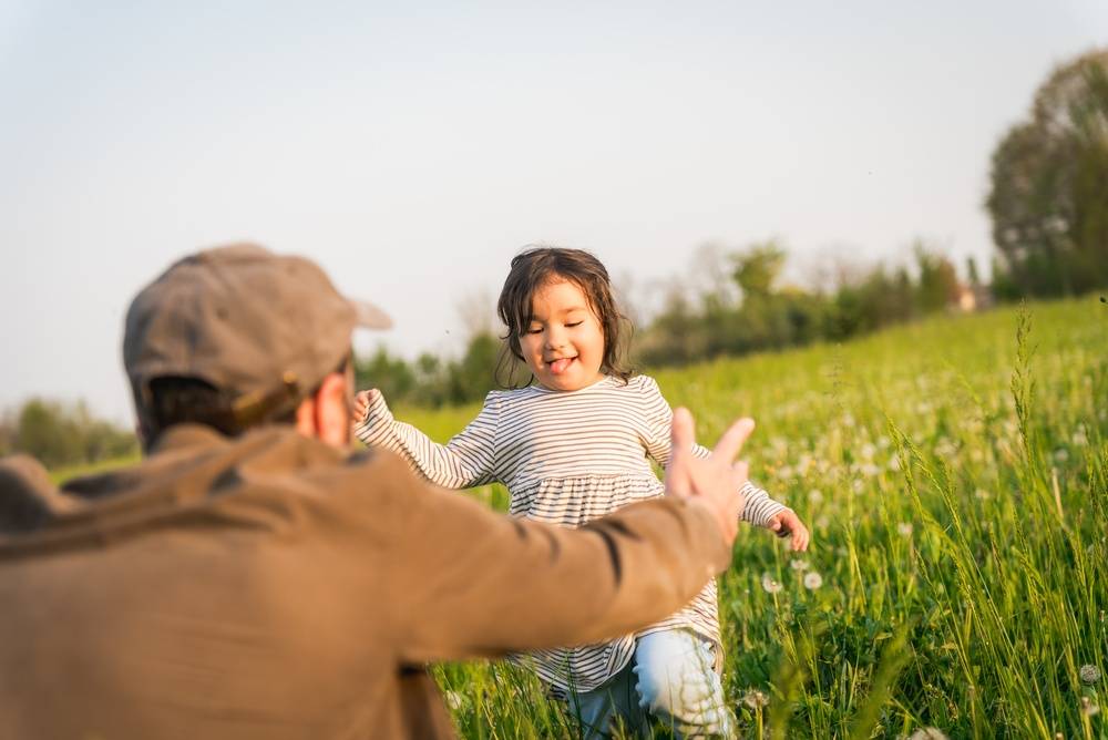 Father hands reaching daughter hugging