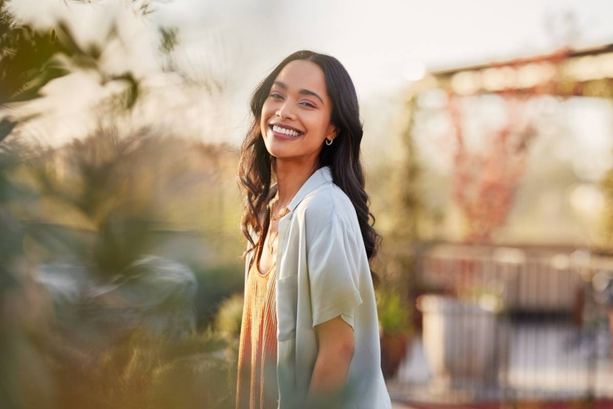 Woman standing outdoors in warm sunlight | Skylum Blog

