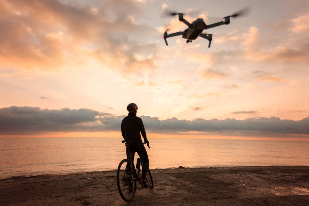 Drone following a person at sunset