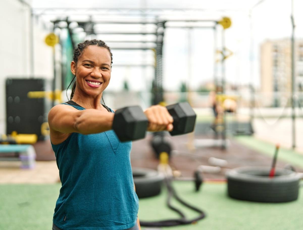 Woman exercising with dumbbells at a gym | Skylum Blog

