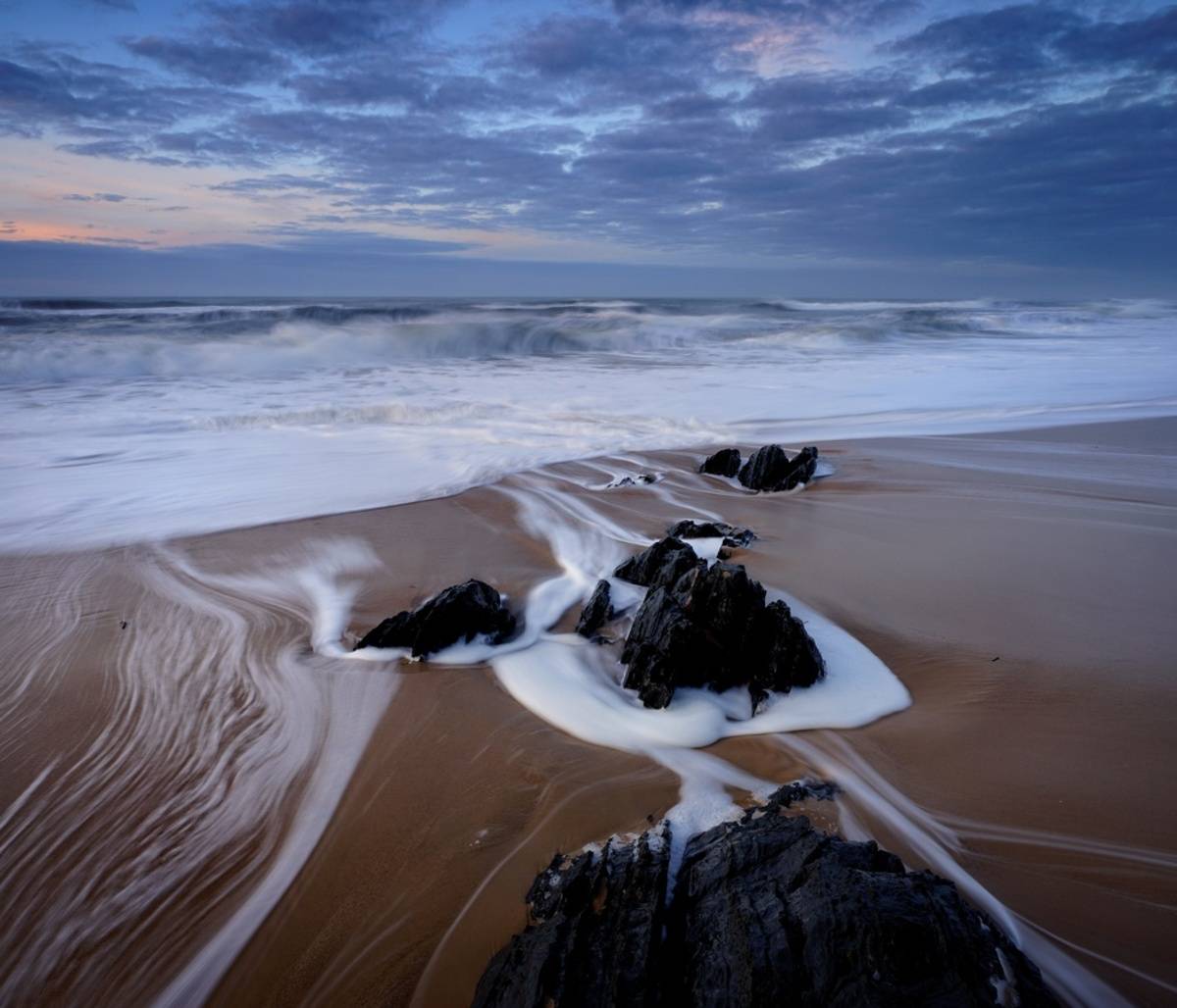 Long exposure seascape with rocks and smooth water | Skylum Blog

