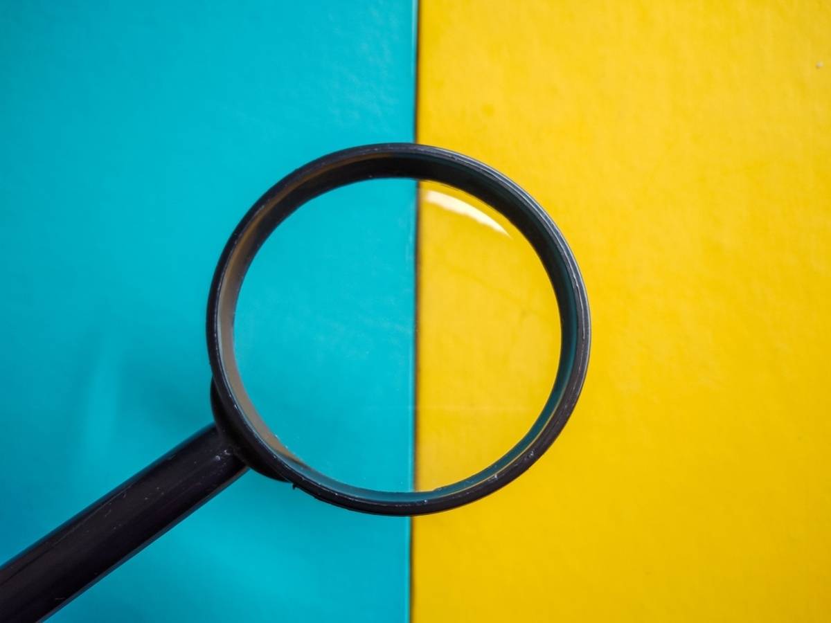 Magnifying glass against a split teal and yellow background