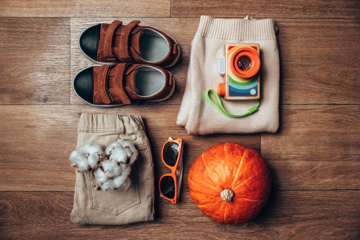 Autumn props flat lay with shoes, camera, pumpkin