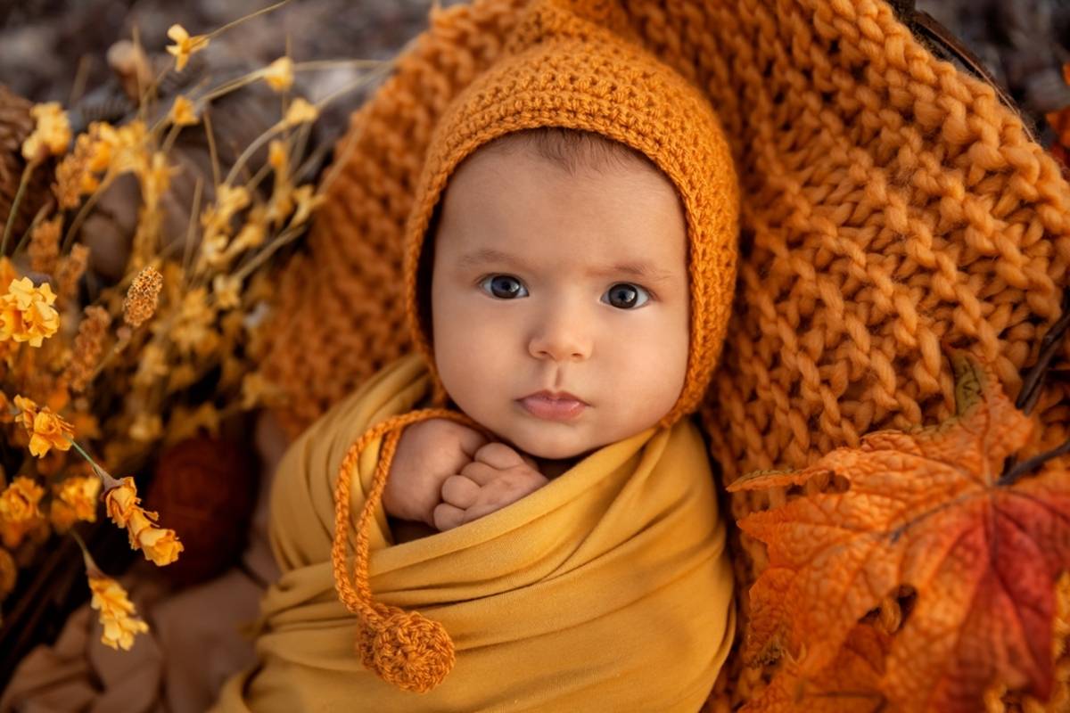 Baby wrapped in warm yellow blanket and hat
