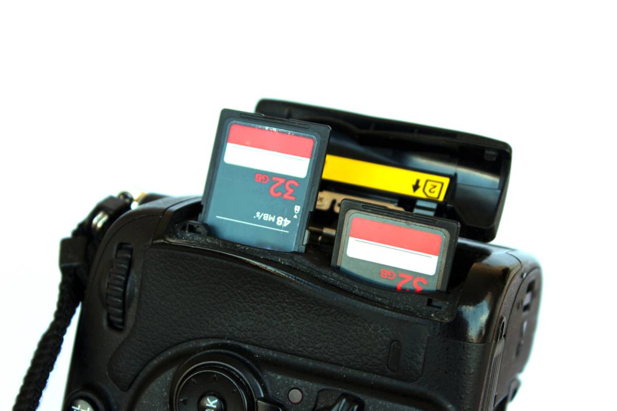 Two SD memory cards, 32GB and 5.2GB, inserted into a dual card slot on a DSLR