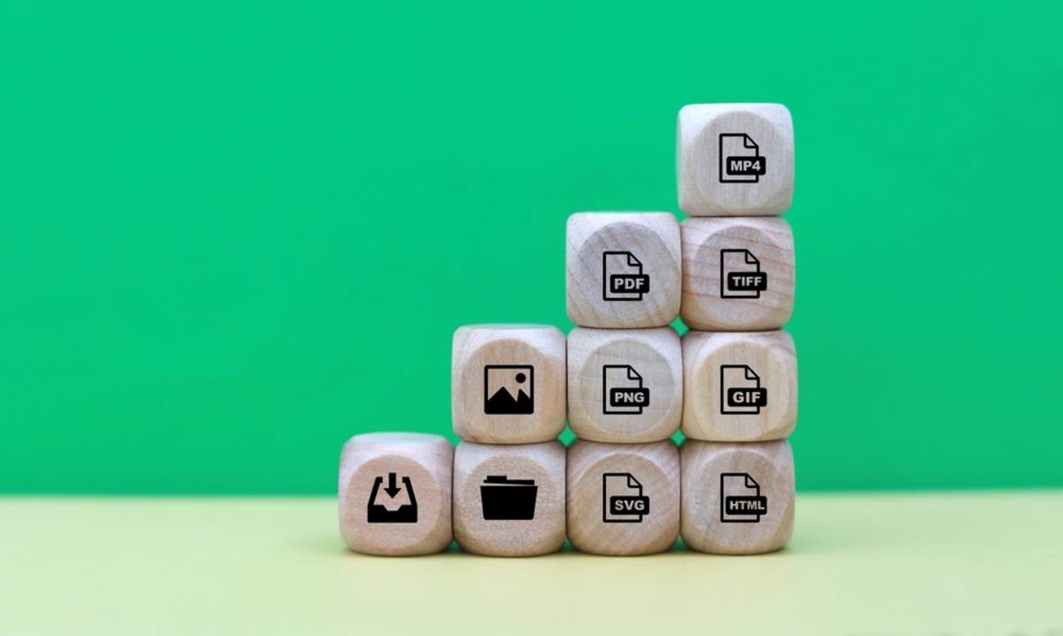 Stacked wooden blocks arranged like stairs, each printed with a file format icon: MP4, PDF, TIFF, PNG, GIF, SVG, HTML