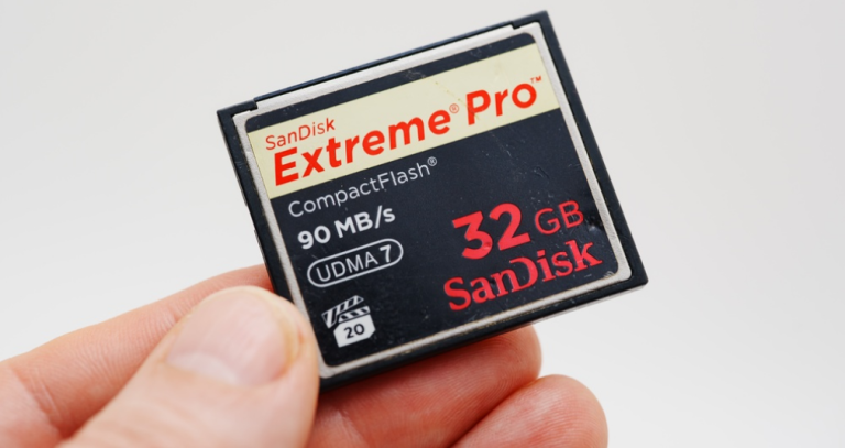 Hand holding a SanDisk Extreme Pro 32GB CompactFlash memory card, 90 MB/s