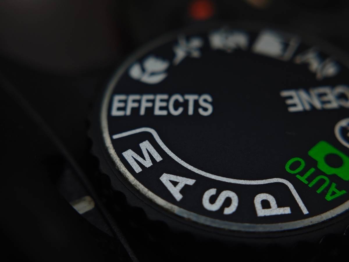 Close-up of a camera mode dial showing M, A, S, P, Auto, Scene and Effects settings