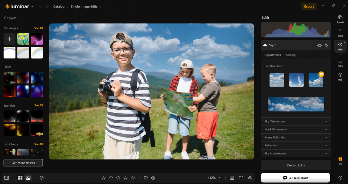 Luminar Sky panel open with Blue Sky 3 preset applied to three kids on a hillside photo