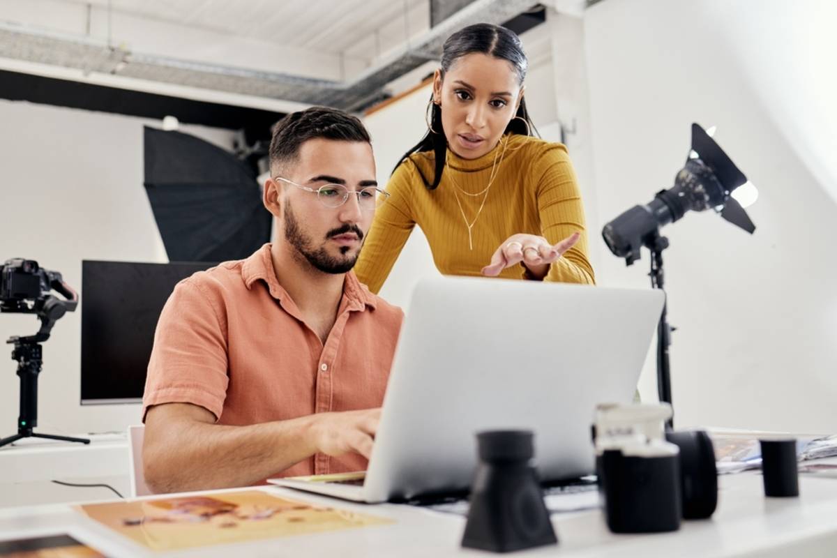Two people using a laptop in a workspace